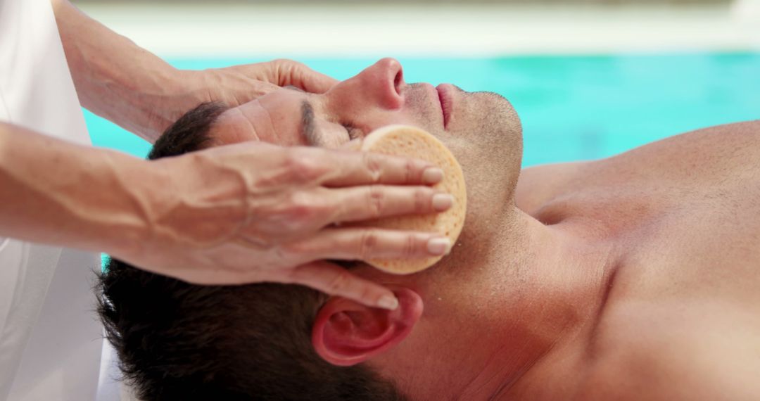 Man Receiving Facial Treatment by Poolside for Relaxation - Free Images, Stock Photos and Pictures on Pikwizard.com