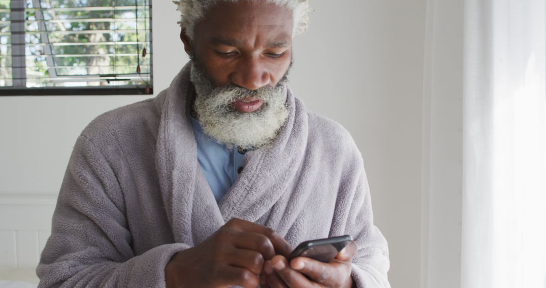 Senior African American Man Texting in Cozy Home Environment - Free Images, Stock Photos and Pictures on Pikwizard.com