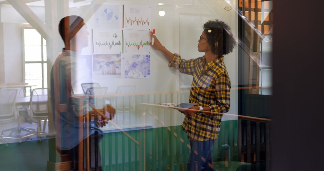 Colleagues Analyzing Graphs in Modern Office Environment