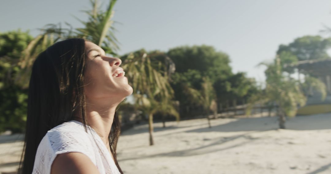 Woman Smiling and Enjoying Sunlight on Tropical Beach - Free Images, Stock Photos and Pictures on Pikwizard.com