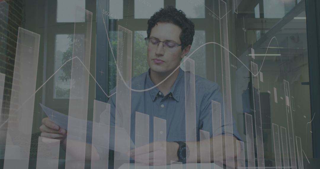 Businessman Analyzing Data with Digital Graphic Overlay in Office