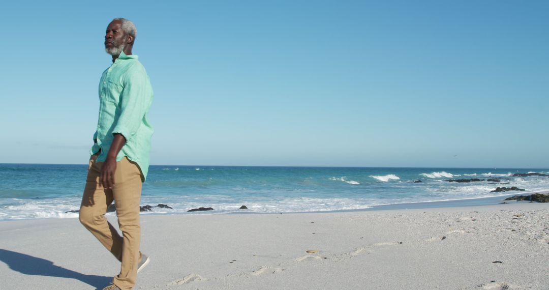 Elderly Man Walking on Sunny Beach - Free Images, Stock Photos and Pictures on Pikwizard.com