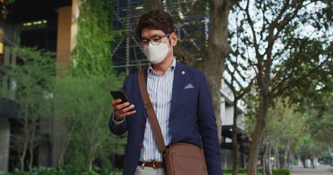 Businessman Wearing Mask Checking Smartphone Outdoors - Free Images, Stock Photos and Pictures on Pikwizard.com