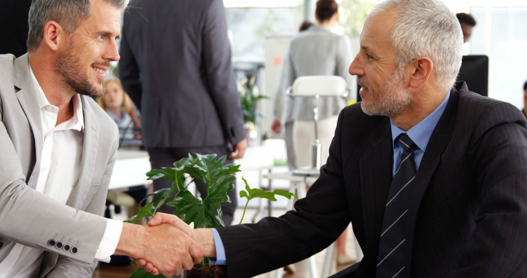 Business Colleagues Shaking Hands in Modern Office Environment