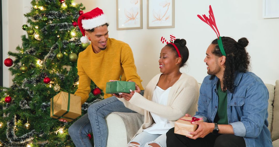 Friends Celebrating Christmas Exchanging Gifts by Tree