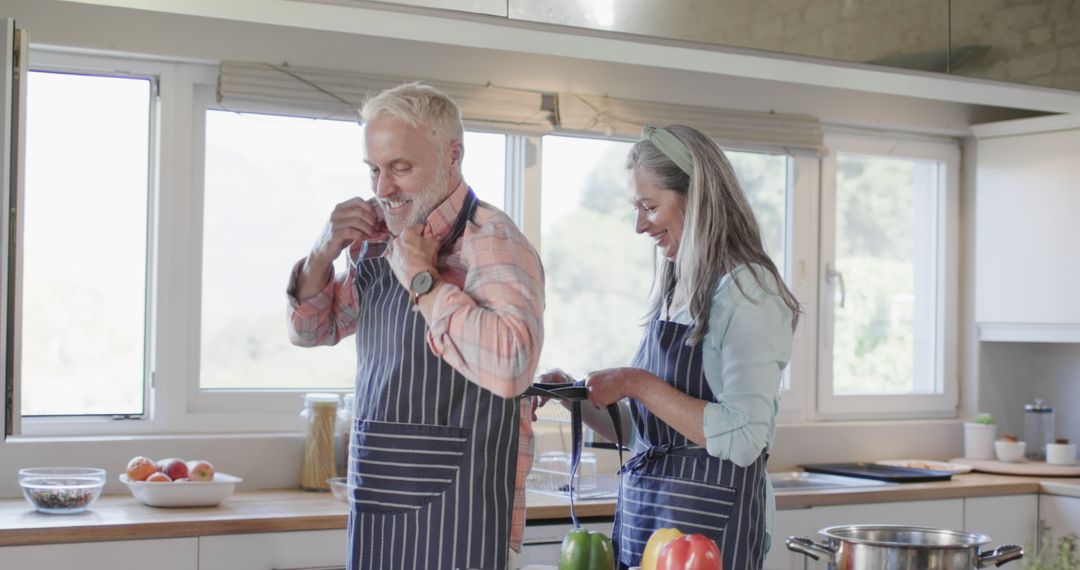 Senior Couple Preparing Meal in Modern Kitchen with Aprons - Free Images, Stock Photos and Pictures on Pikwizard.com