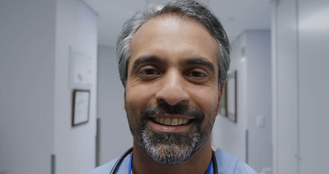 Confident Smiling Doctor with Stethoscope in Modern Hospital Corridor - Free Images, Stock Photos and Pictures on Pikwizard.com