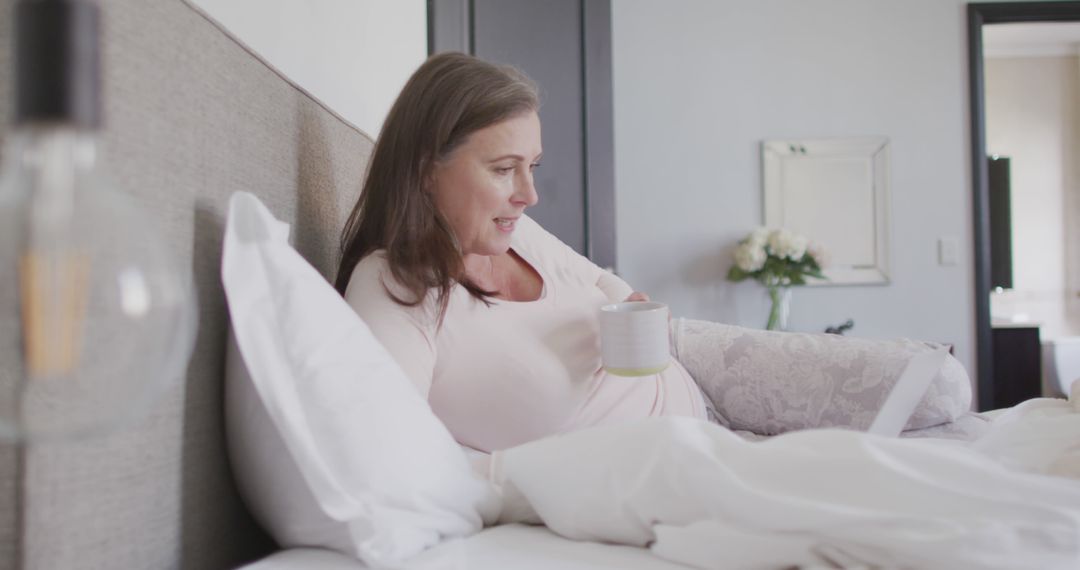 Pregnant Woman Relaxing in Bed with Morning Drink - Free Images, Stock Photos and Pictures on Pikwizard.com