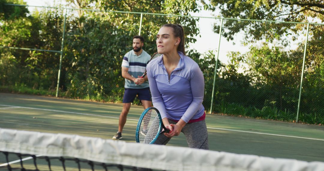 Focused Mixed Doubles Team Playing Tennis on Outdoor Court - Free Images, Stock Photos and Pictures on Pikwizard.com