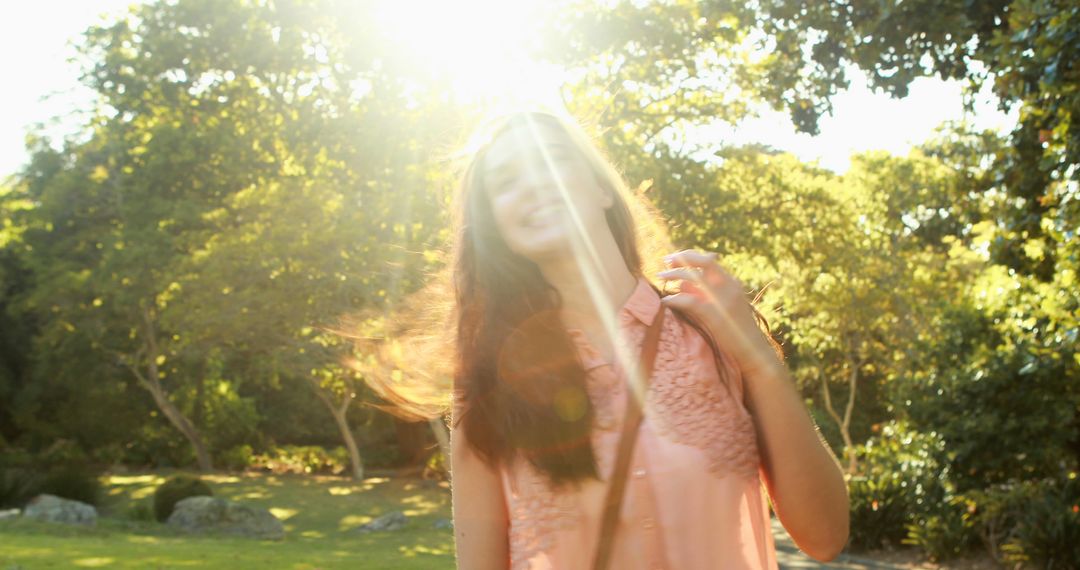 Joyful Young Woman Embracing Nature in Sunlit Park - Free Images, Stock Photos and Pictures on Pikwizard.com