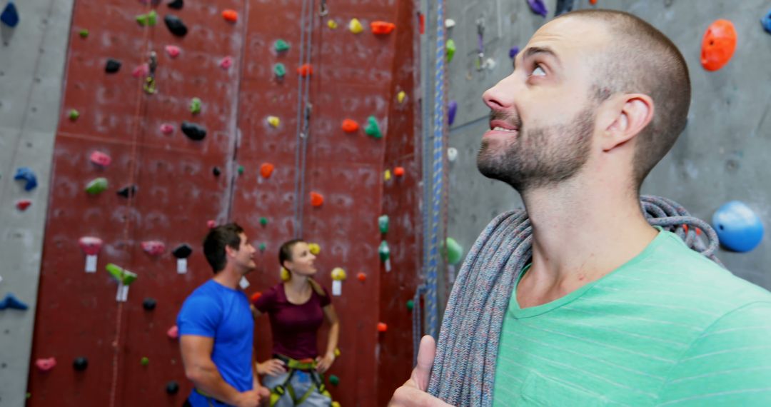 Man Looking Up in Indoor Climbing Gym with Friends - Free Images, Stock Photos and Pictures on Pikwizard.com