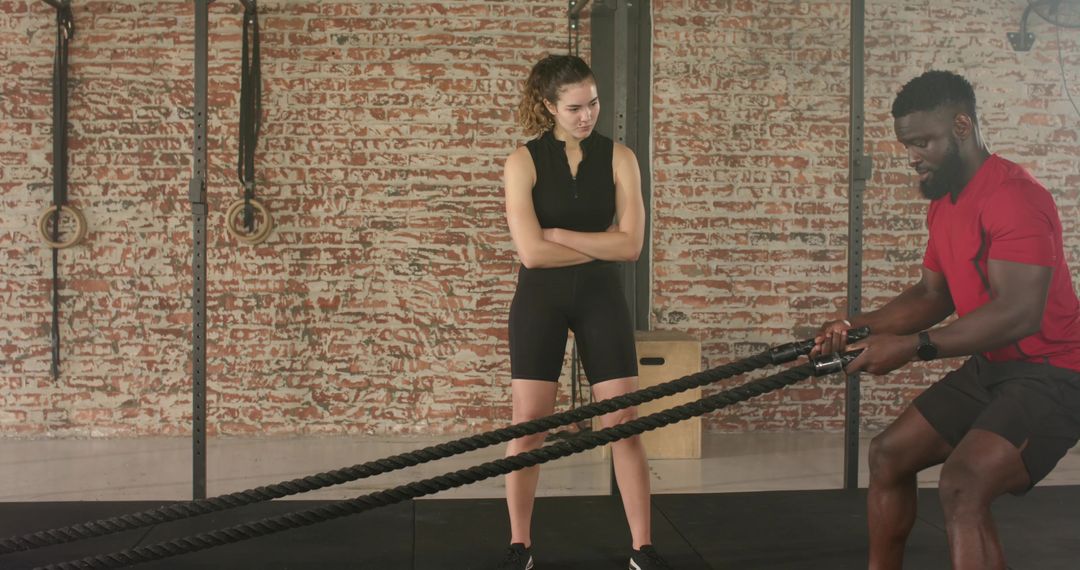 Cross Trainer Guiding Tier Workout With Battle Ropes