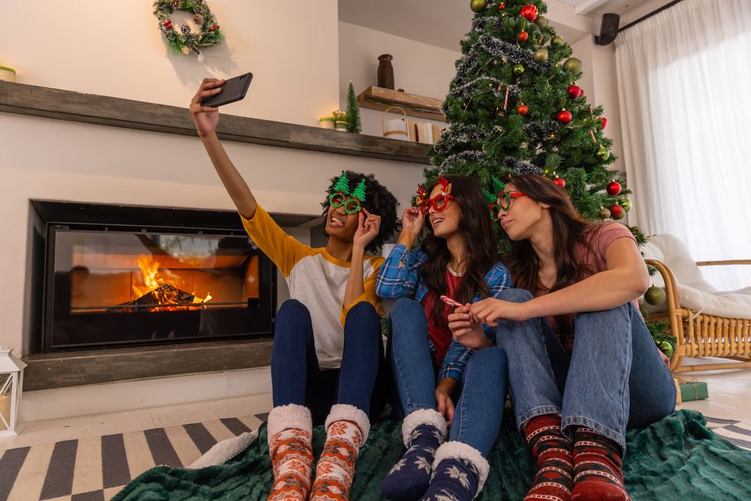 Friends Celebrating Christmas Taking Selfie by Festive Tree