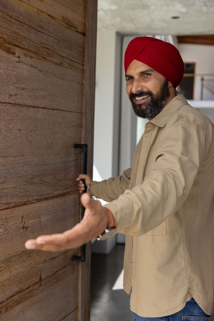 Indian Man with Red Turban Welcoming Guests in Modern Home
