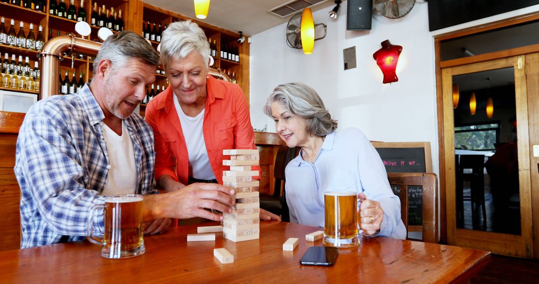 Friends Enjoying Jenga Game in Cozy Bar Setting