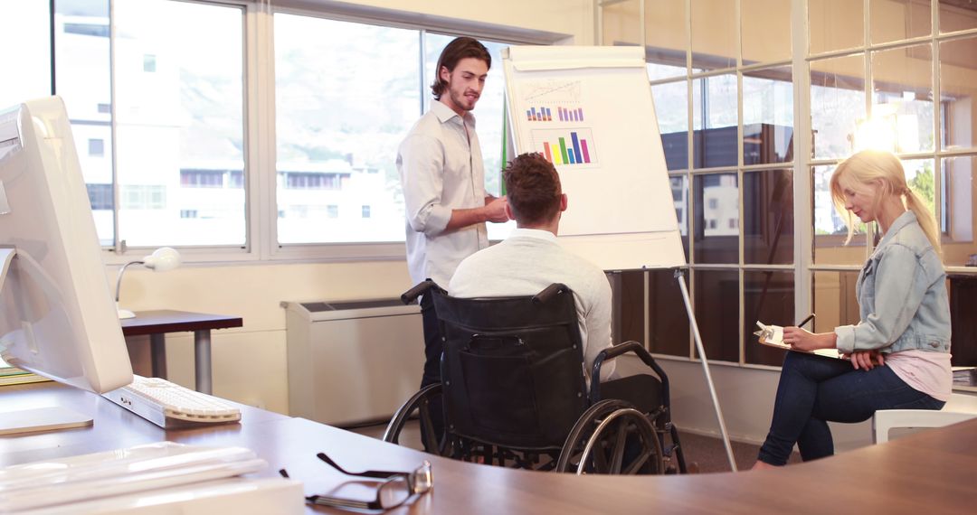 Businessman in Wheelchair Analyzing Sales Data with Colleagues - Free Images, Stock Photos and Pictures on Pikwizard.com