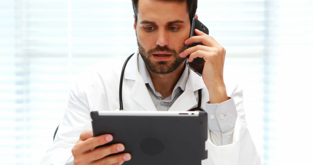 Doctor Using Tablet and Talking on Phone in Office - Free Images, Stock Photos and Pictures on Pikwizard.com