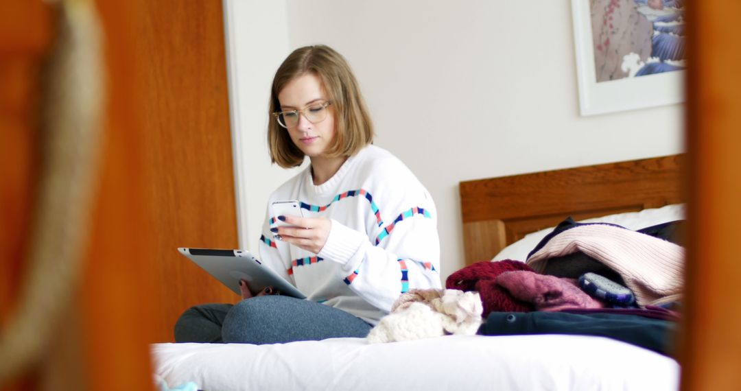 Young Woman Using Smartphone and Tablet on Bed in Cozy Bedroom - Free Images, Stock Photos and Pictures on Pikwizard.com