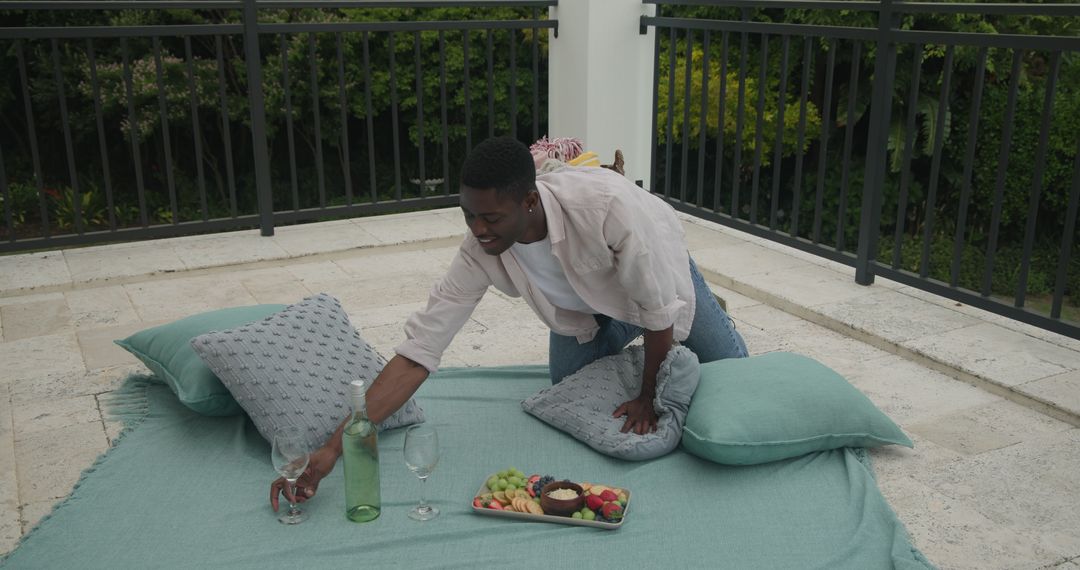 Man Setting Up Cushioned Outdoor Picnic for Relaxation