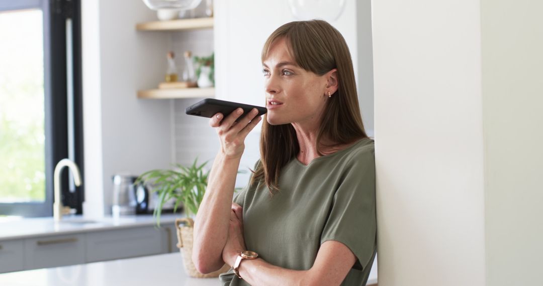 Woman Using Voice Command on Smartphone in Modern Kitchen
