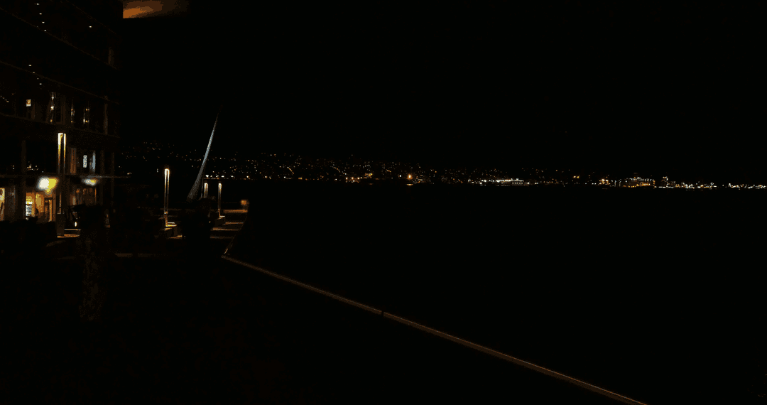 Cityscape at Night with Distant Lights and Reflective Water Surface