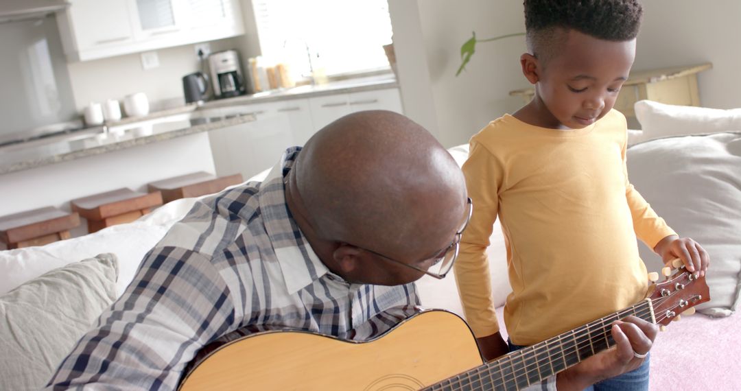 Father teaching son to play acoustic guitar in living room - Free Images, Stock Photos and Pictures on Pikwizard.com