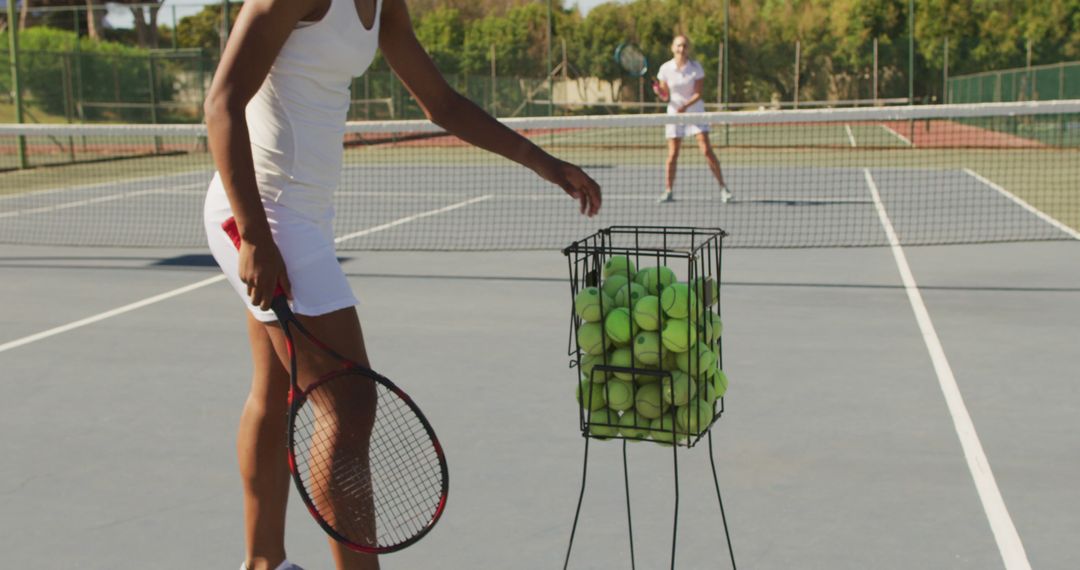 Image of african american female tennis player holding racket and training with friend - Free Images, Stock Photos and Pictures on Pikwizard.com