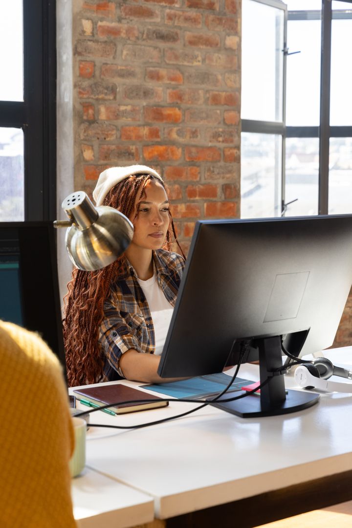 Modern Urban Office with Focused Diverse Coworker Using Computer