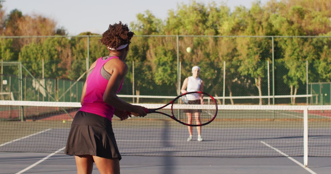 Image of back of african american female tennis player holding racket and hitting ball - Free Images, Stock Photos and Pictures on Pikwizard.com