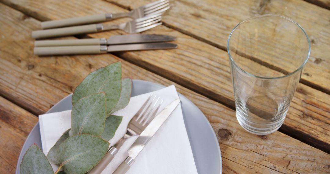 Rustic Dining Table Setting with Silverware and Glass on Wooden Surface - Free Images, Stock Photos and Pictures on Pikwizard.com