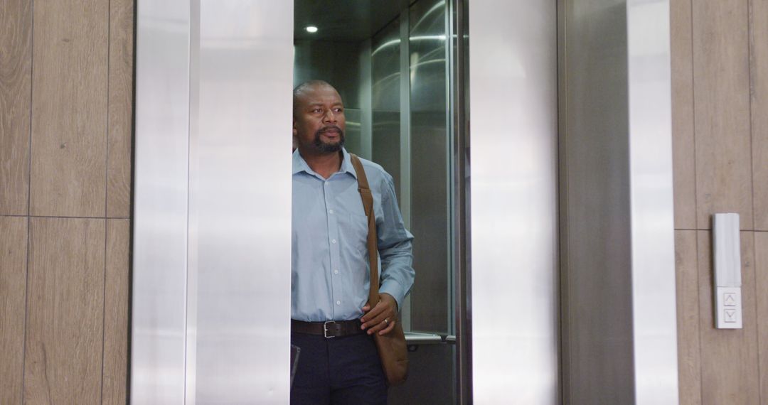 African american businessman using elevator at office - Free Images, Stock Photos and Pictures on Pikwizard.com