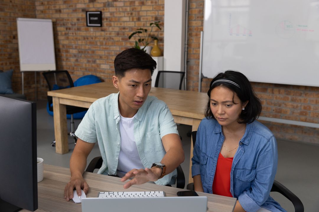 Team Reviewing Reports and Whiteboard in Modern Office Environment