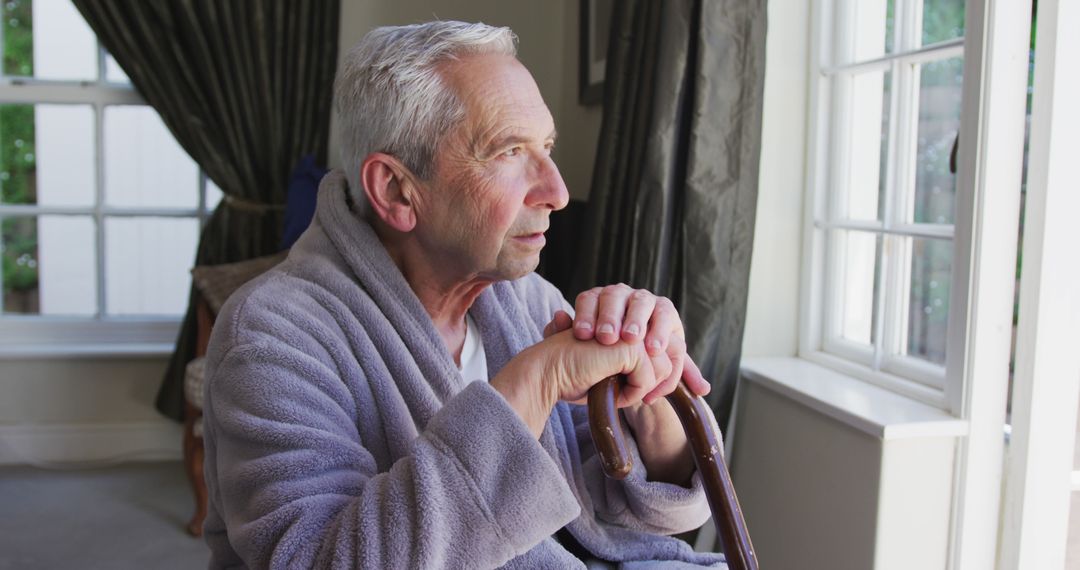 Pensive Elderly Man Sitting by Window with Cane - Free Images, Stock Photos and Pictures on Pikwizard.com