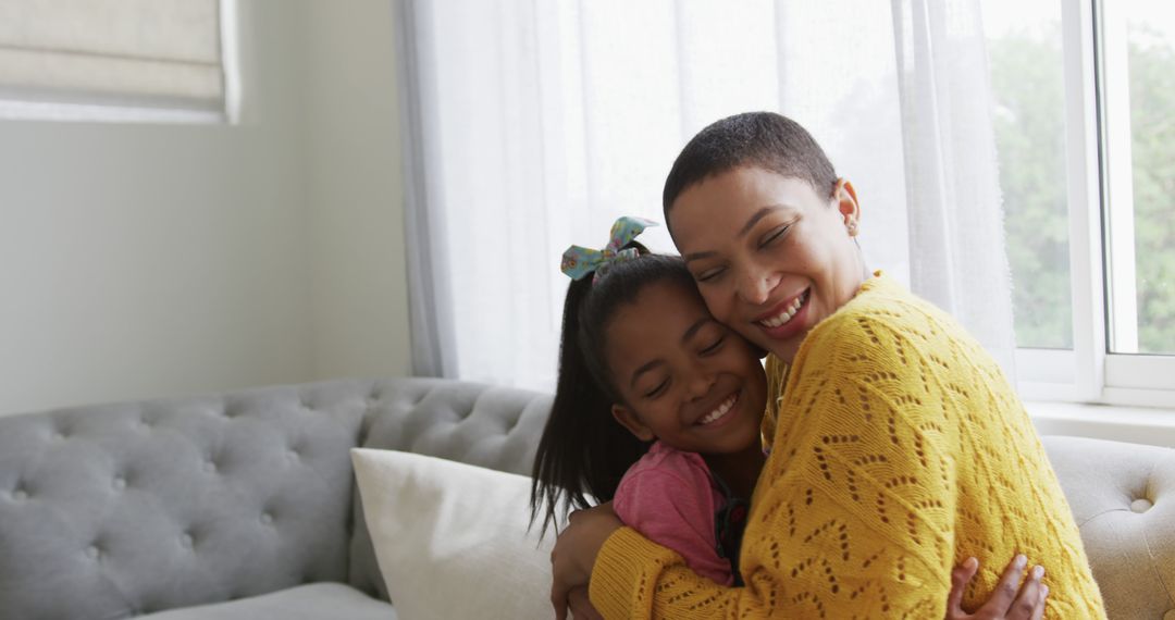 Joyful Mother and Daughter Hugging on Couch by Window - Free Images, Stock Photos and Pictures on Pikwizard.com