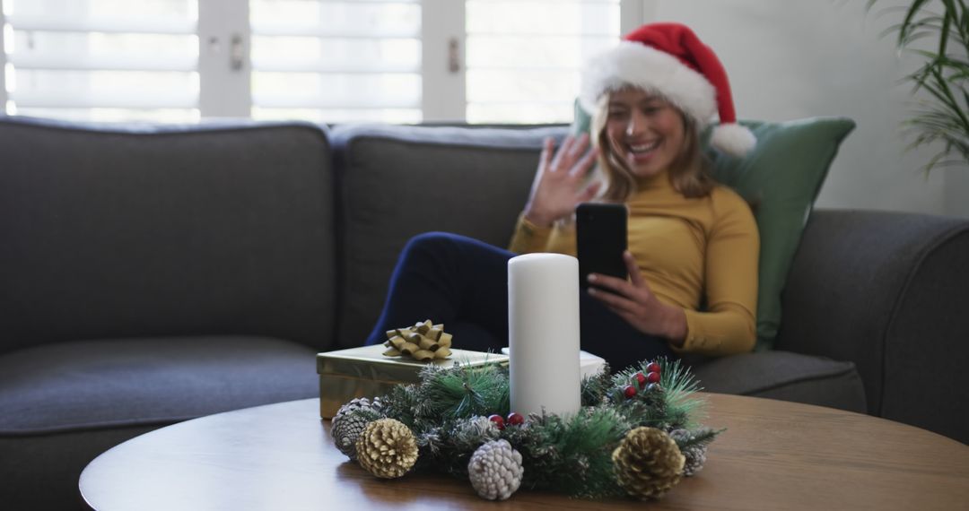 Young Woman in Santa Hat Video Calling During Christmas Celebration - Free Images, Stock Photos and Pictures on Pikwizard.com