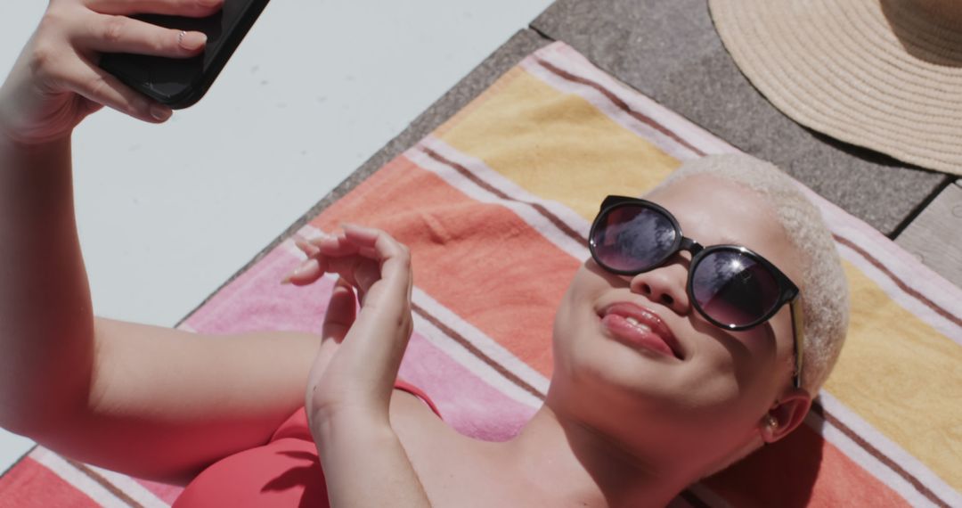 Relaxed Woman Sunbathing and Taking Selfie by Poolside - Free Images, Stock Photos and Pictures on Pikwizard.com