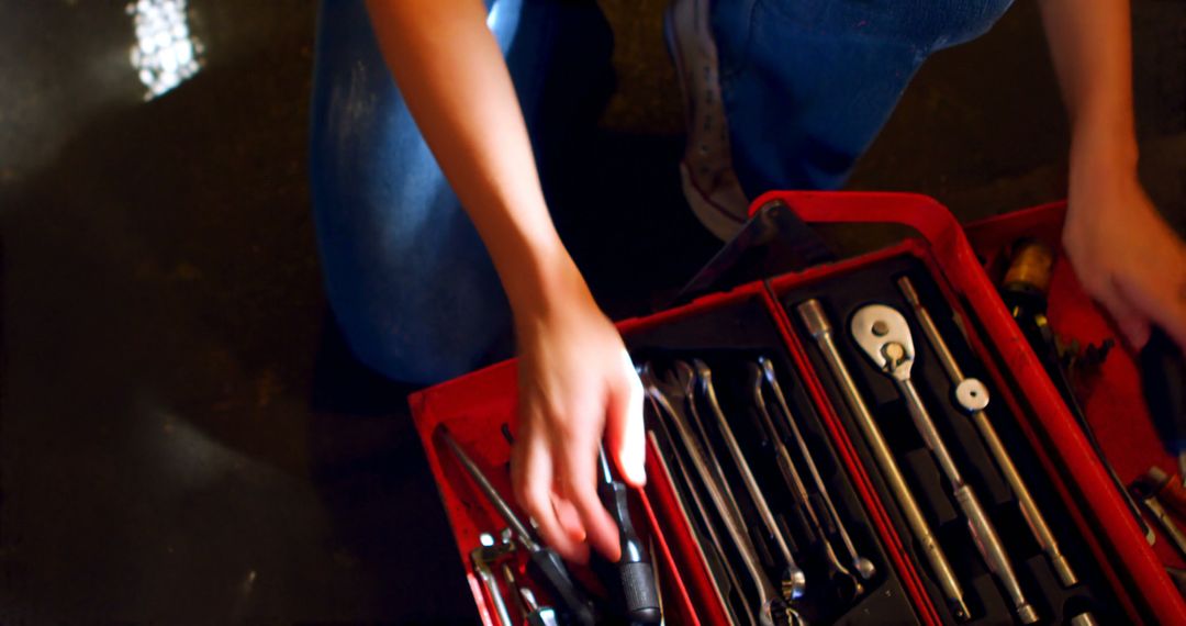 Person reaches for a tool in a red toolbox, with copy space - Free Images, Stock Photos and Pictures on Pikwizard.com