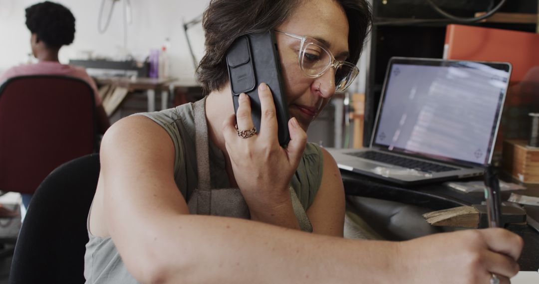 Jewellery Designer Communicating on Smartphone in Creative Workshop