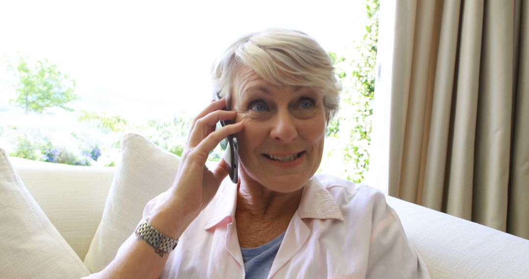 Senior Woman Smiling During Phone Conversation in Living Room - Free Images, Stock Photos and Pictures on Pikwizard.com