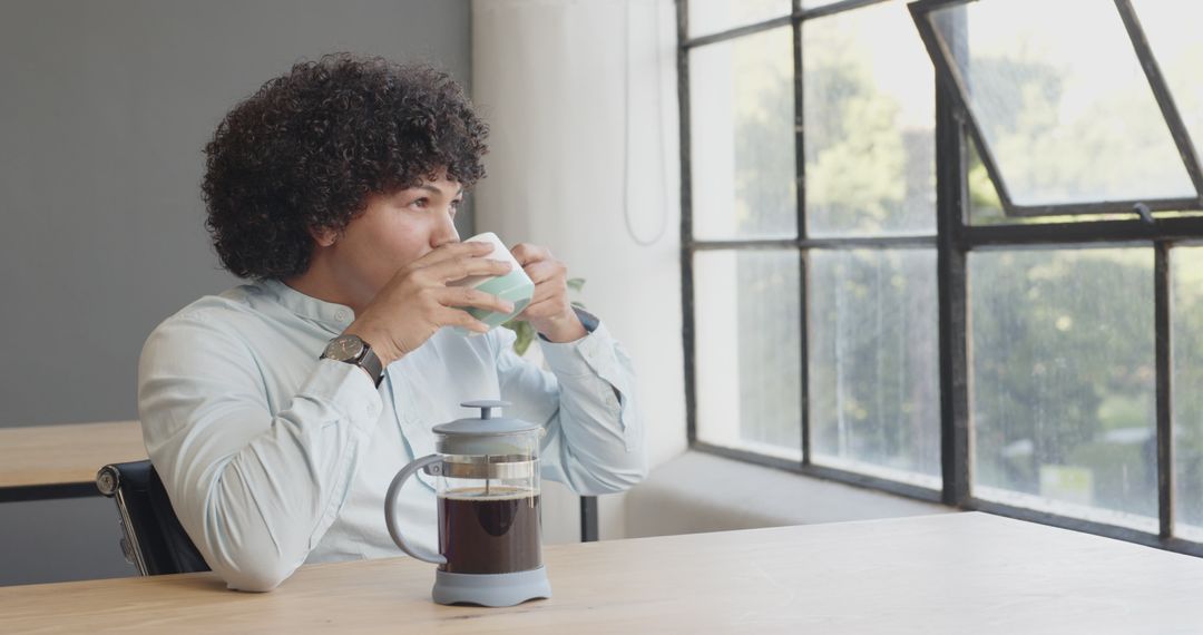 Young Professional Enjoys Coffee Break in Modern Office