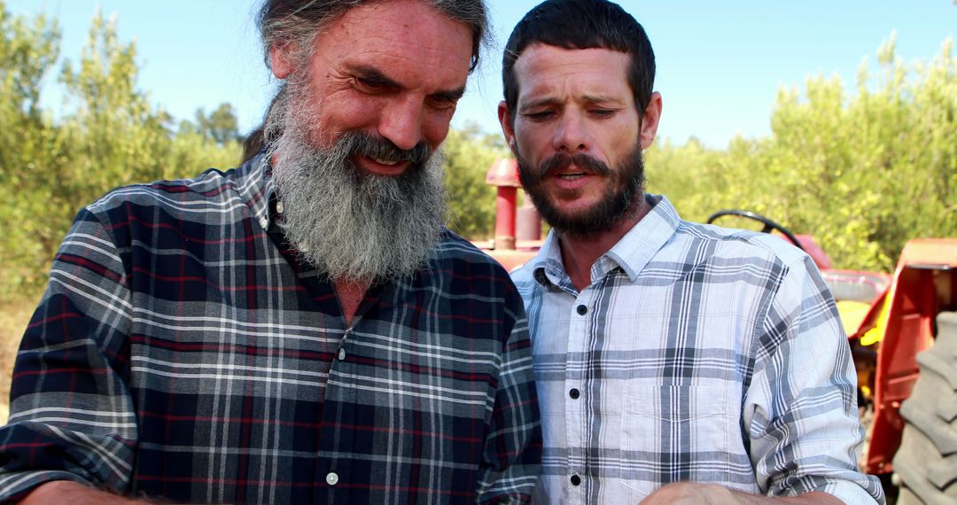 Two Men in Plaid Shirts Using Smartphone in Outdoors - Free Images, Stock Photos and Pictures on Pikwizard.com