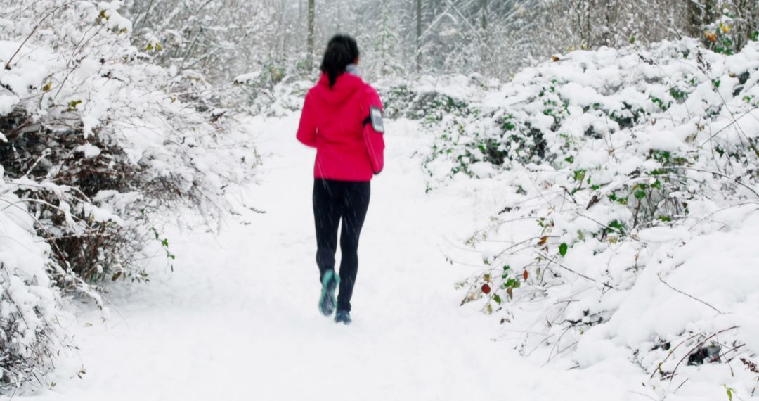 Woman running on snowy path in winter forest - Free Images, Stock Photos and Pictures on Pikwizard.com