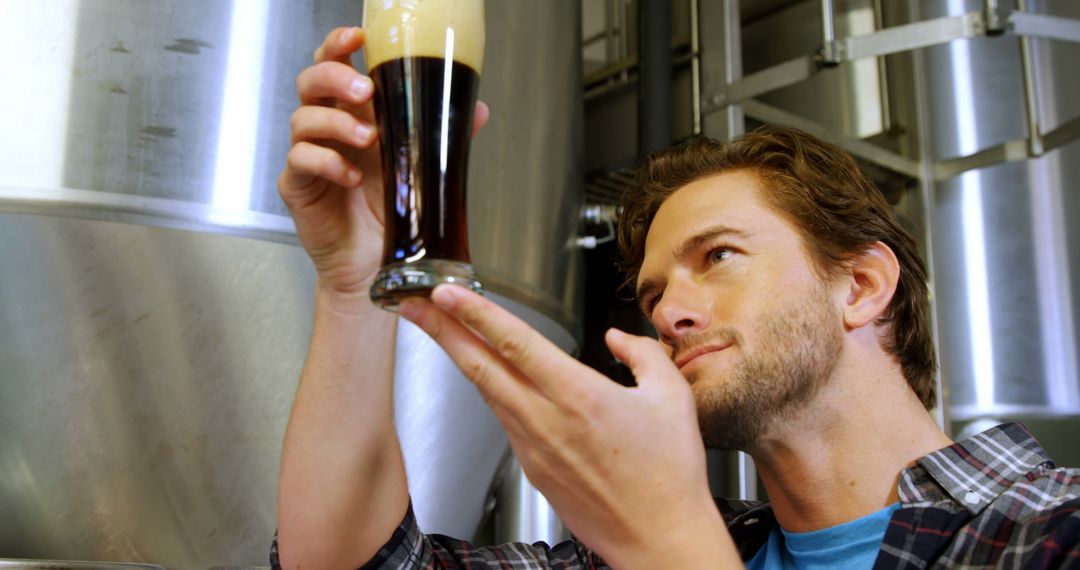 Young Brewer Carefully Examining Dark Beer Quality in Brewery - Free Images, Stock Photos and Pictures on Pikwizard.com