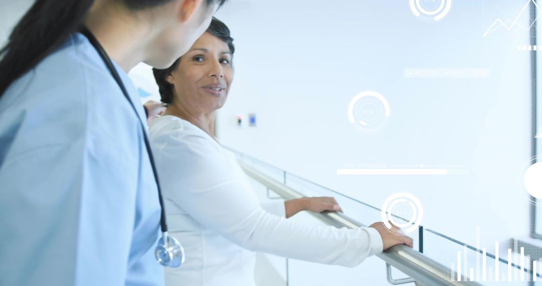 Mature patient talking with nurse while leaning on railing in modern clinical corridor