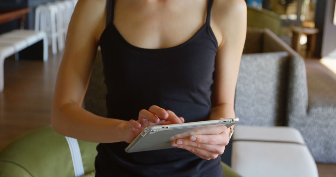 Casual Woman Typing on Tablet in Modern Interior - Free Images, Stock Photos and Pictures on Pikwizard.com