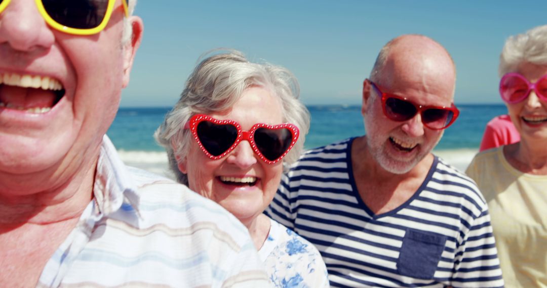 Joyful Seniors Wearing Heart-shaped Sunglasses Having Fun at Beach - Free Images, Stock Photos and Pictures on Pikwizard.com