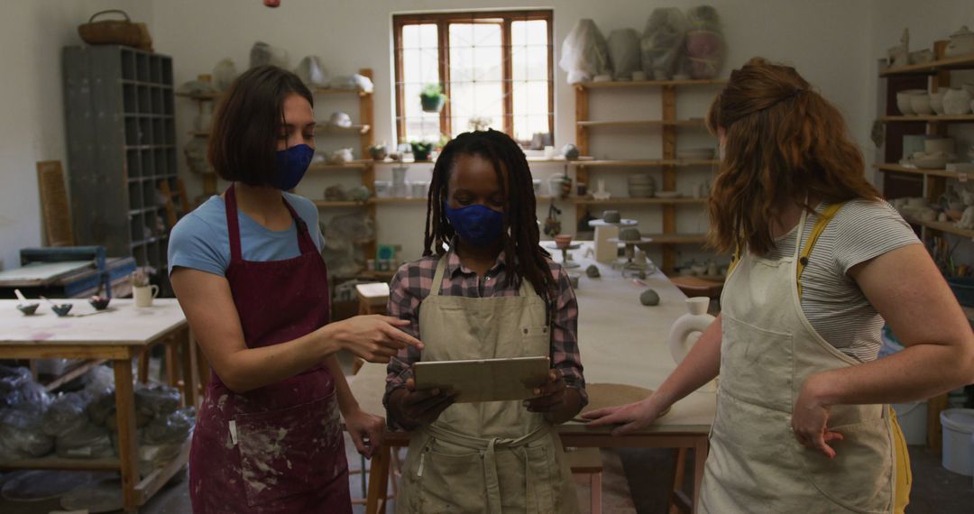 Women Collaborating on Tablet in Ceramics Studio - Free Images, Stock Photos and Pictures on Pikwizard.com