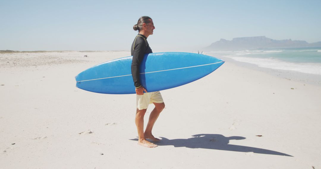 Surfer Carrying Longboard on Sunny Beach - Free Images, Stock Photos and Pictures on Pikwizard.com