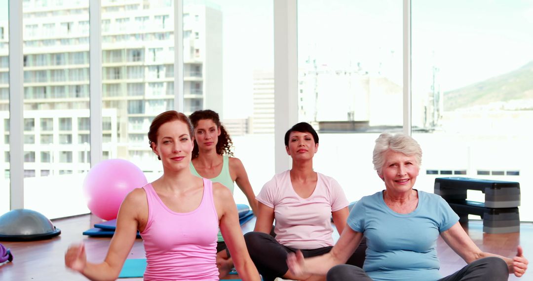 Women Practicing Yoga Together in Bright Fitness Studio - Free Images, Stock Photos and Pictures on Pikwizard.com