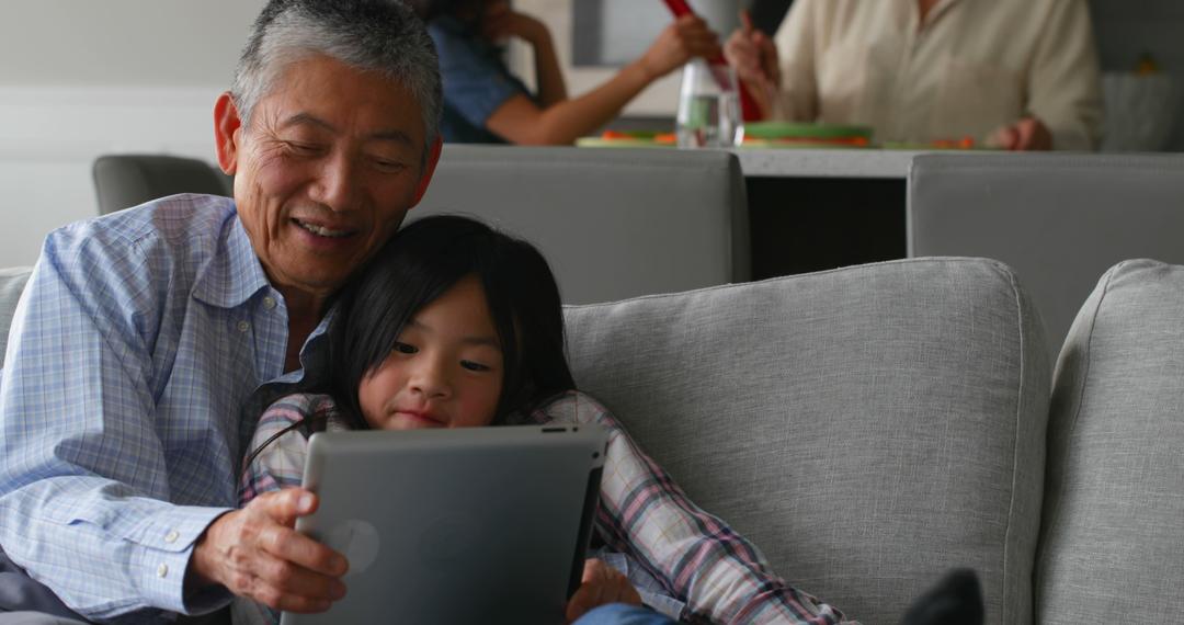 Grandfather and Granddaughter Using Tablet Together at Home - Free Images, Stock Photos and Pictures on Pikwizard.com